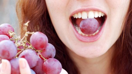 Девушка ест виноград